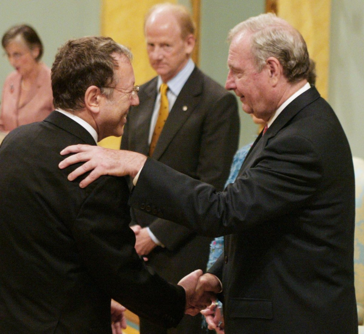 Irwin Cotler (right) shakes hands with former prime minister Paul Martin during the cabinet swearing in ceremony in Ottawa Tuesday July 20, 2004.(CP PHOTO/Fred Chartrand).