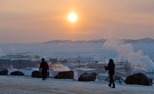 People walk along a path in Iqaluit, Nunavut on Tuesday, December 9, 2014. 