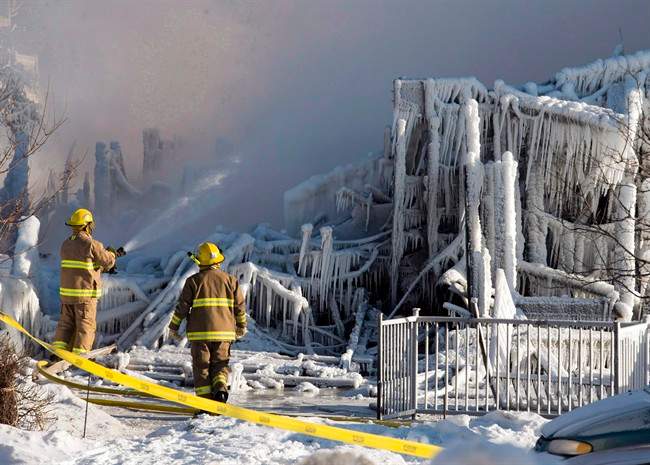 Firefighters work at the scene of a fatal fire at a seniors residence in L'Isle-Verte, Que., Thursday, January 23, 2014.