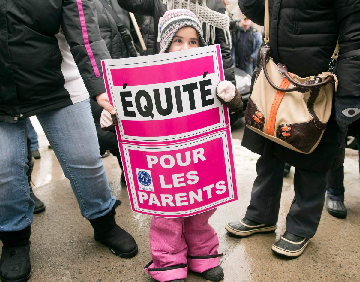 A young child takes part in a daycare workers protest in front of the offices of Premier Pauline Marois Tuesday, February 12, 2013 in Montreal. The workers staged a one-day strike to protest the allocation of new daycare spaces.
