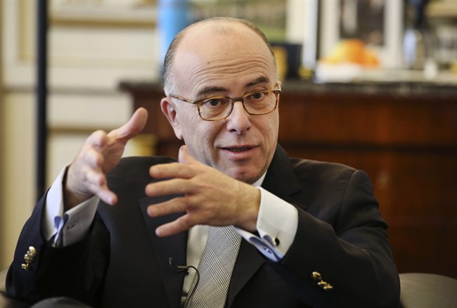 In this photo taken on Monday Feb. 16, 2015, French interior minister Bernard Cazeneuve gestures during an interview with the Associated Press, at his office in Paris. 