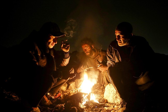In this Wednesday, Feb. 11, 2015 photo, drug addicts gather around fire to warm themselves, in a suburb of Tehran, Iran.