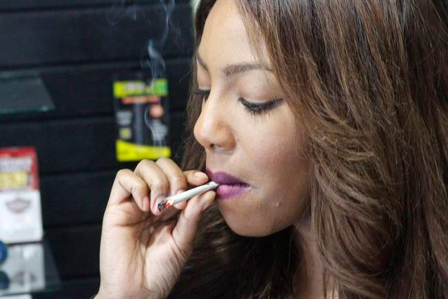 In this Feb. 20, 2015 photo, Alaska Cannabis Club CEO Charlo Greene smokes a joint at the medical marijuana dispensary in Anchorage, Alaska. On Tuesday, Feb. 24, 2015, Alaska will become the third state in the nation to legalize marijuana.