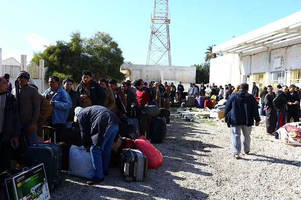 Egyptians wait with their belongings to cross from Libya to Tunisia, via the the Ras Djir border crossing, on February 23, 2015 for a flight evacuating them back to Cairo.