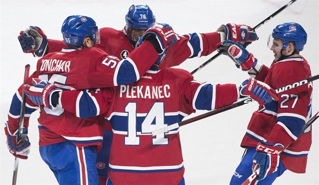 Montreal Canadiens' Tomas Plekanec (14) celebrates with teammates Sergei Gonchar (55), P.K. Subban (76) and Alex Galchenyuk after scoring against the New Jersey Devils during second period NHL hockey action in Montreal, Saturday, February 7, 2015. 