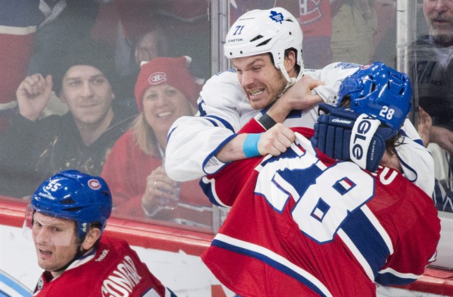 Montreal Canadiens' Nathan Beaulieu fights with Toronto Maple Leafs' David Clarkson (71) after Clarkson ran Canadiens' Sergei Gonchar (left) into the boards during first period NHL hockey action in Montreal.