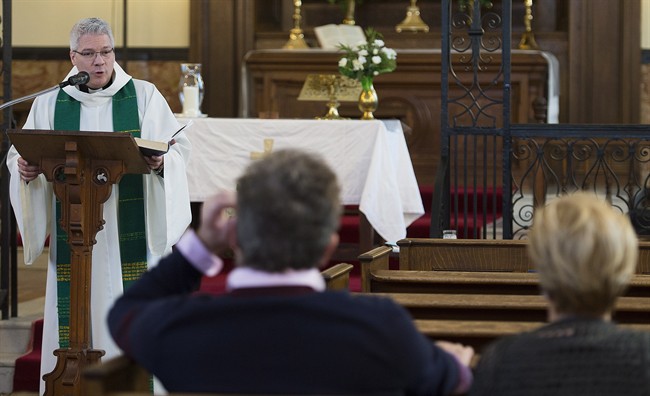 Reverend Yves Samson speaks to the faithful during mass at St. James Anglican Church in Trois-Rivières, Que.