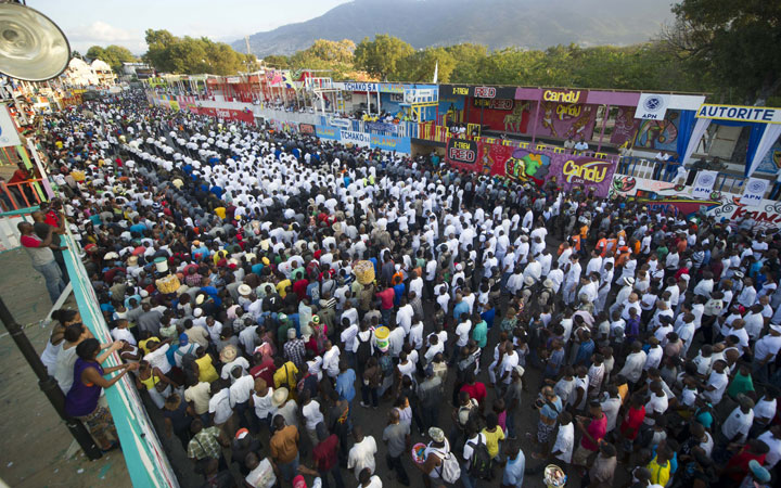 Haitian mourners walk down a street during a march convened by the government in Port-au-Prince on February 17, 2015, in memory of the victims who died during celebrations in the National Carnival of Haiti.