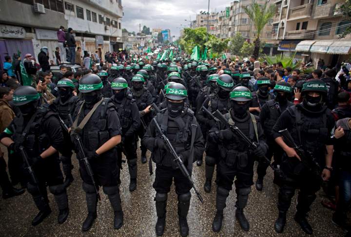 Masked Palestinian Hamas gunmen display their military skills during a rally to commemorate the 27th anniversary of the Hamas militant group, in Gaza City, Dec. 2014.