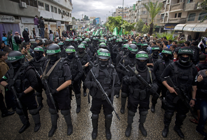 Masked Palestinian Hamas gunmen display their military skills during a rally to commemorate the 27th anniversary of the Hamas militant group, in Gaza City, Dec. 2014.
