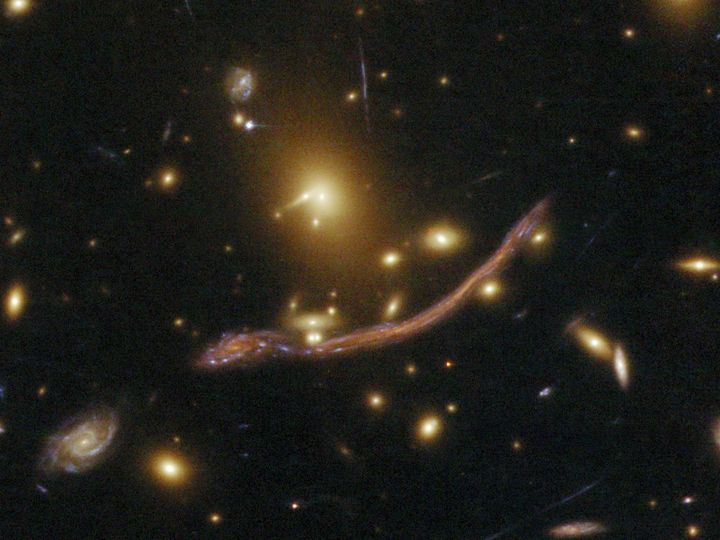 This image, taken by Hubble in 2009, shows another effect of gravitational lensing. You can see how the one galaxy at the bottom seems stretched out.