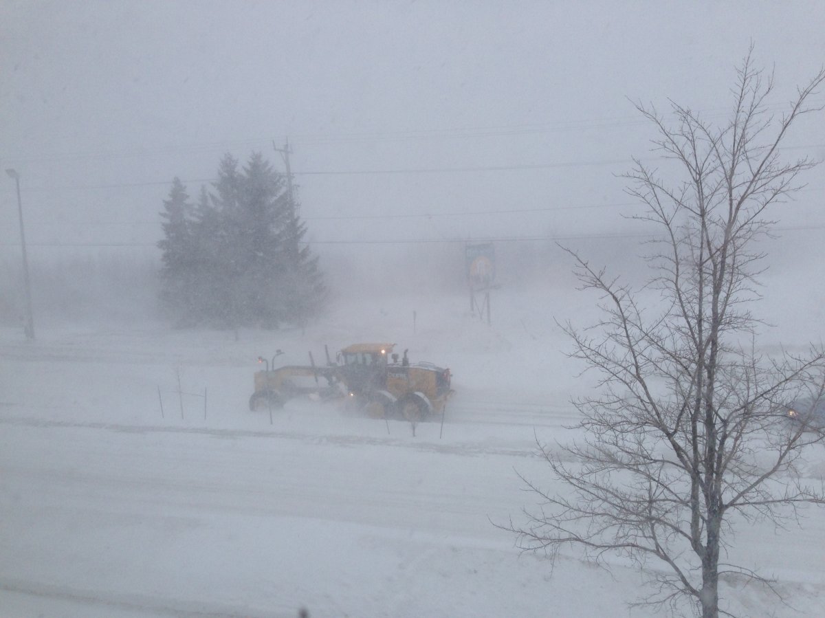 A plow drives  along Vaughan Harvey Boulevard in Moncton, NB during heavy snowfall Sunday morning.