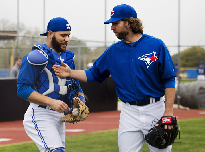 Toronto Blue Jays starting pitcher R.A. Dickey talks with Blue Jays catcher Russell Martin after pitching in the bullpen during baseball spring training in Dunedin, Fla., on Wednesday, February 25, 2015. 
