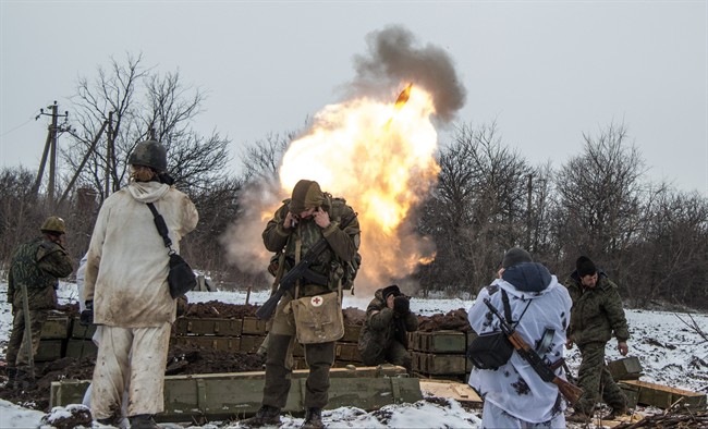Russian-backed separatists cover their ears as they fire a mortar towards Ukrainian troops outside the village of Sanzharivka, northeast of Debaltseve, eastern Ukraine, Wednesday, Feb. 11, 2015. The leaders of France, Germany, Russia and Ukraine flew to the Belarus capital for crucial peace talks Wednesday as fighting still raged in eastern Ukraine. 
