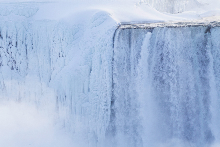 Water still rushes down the falls, though masses of ice have accumulated.
