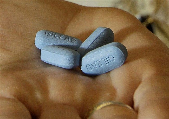 In this file photo, a doctor holds Truvada pills at her office in San Francisco.