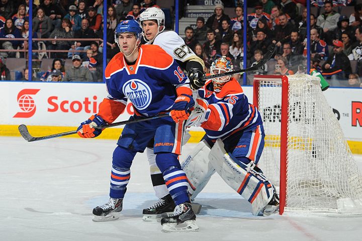 Justin Schultz #19 and Viktor Fasth #35 of the Edmonton Oilers battle for position against Sidney Crosby #87 of the Pittsburg Penguins on February 4, 2015 at Rexall Place in Edmonton, Alberta, Canada.