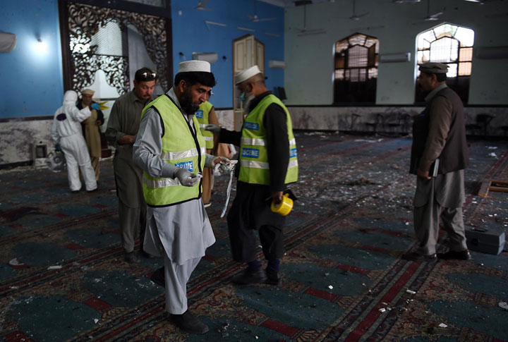 Pakistani security officials and volunteers collect evidence at a Shiite Muslim mosque after it was attacked by Taliban militants in Peshawar on February 13, 2015. 