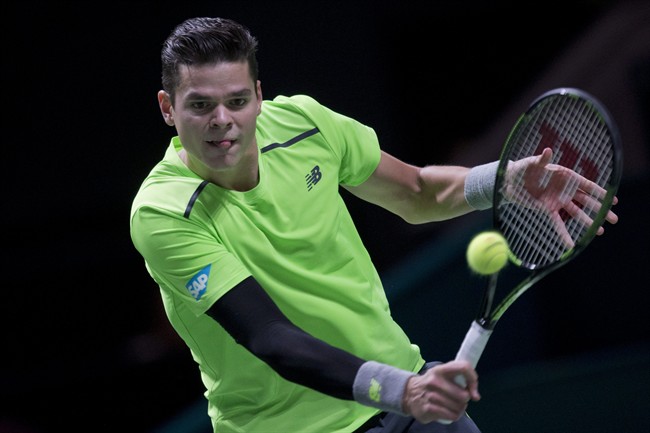 Milos Raonic returns the ball to Russia's Andrey Kuznetsov during their first round match of the 42nd ABN AMRO world tennis tournament at Ahoy Arena in Rotterdam, Netherlands, Tuesday, Feb. 10, 2015.