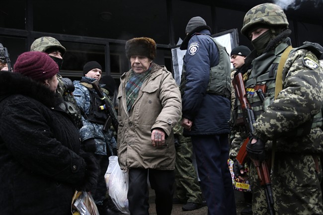 Soldiers stand guard as humanitarian aid is distributed to residents in the town of Debaltseve, Ukraine, Friday, Feb. 6, 2015. 