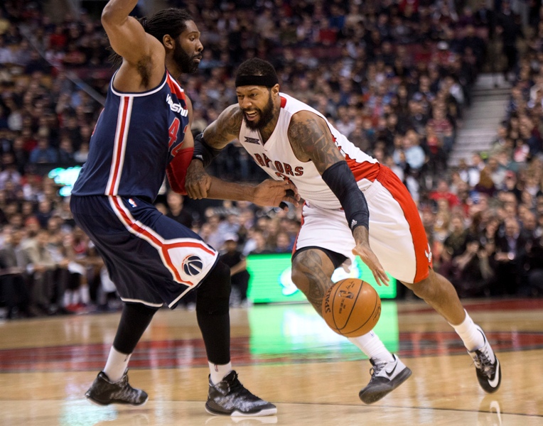 Toronto Raptors forward James Johnson, right, drives into Washington Wizards forward Nene, left, during first half NBA basketball action in Toronto on Wednesday, February 11, 2015. 