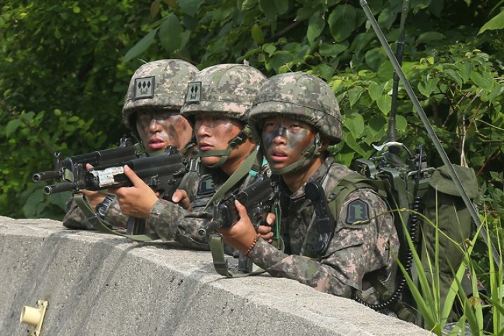 South Korean army soldiers aim their machine guns during an arrest operation in Goseong, South Korea, Monday, June 23, 2014. The soldier arrested was given a life sentence on February 2, 2015.