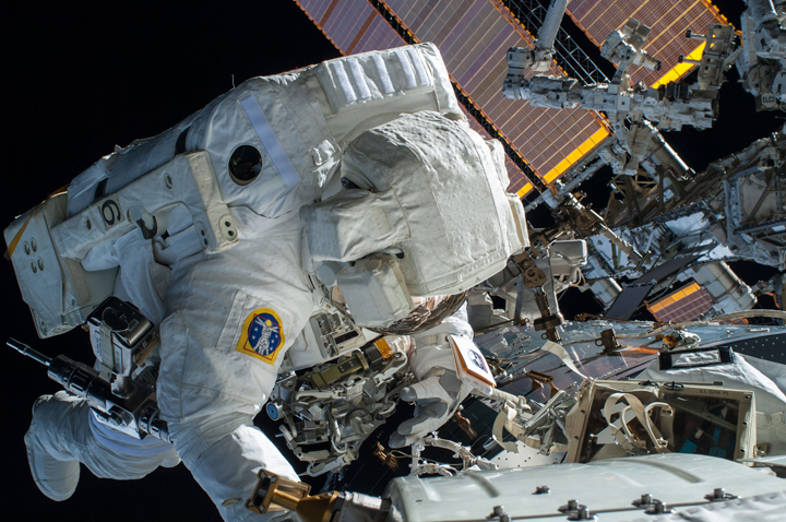 NASA astronaut Terry, Virts is seen working to complete a cable routing task while near the forward facing port of the Harmony module on the International Space Station. 