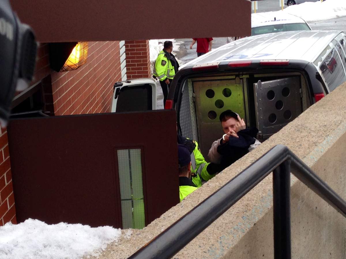 Daniel Surette gives a rude gesture to media as he arrives at Kentville court on Monday, February 23, 2015.