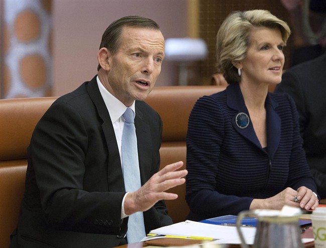 In this Sept. 18, 2013 file photo, Australian Prime Minister Tony Abbott, left, leads the first meeting of his full ministry in the Cabinet Room of Parliament House in Canberra, Australia. The fight over conservative Prime Minister Abbott’s leadership broke out into the open on Friday, Feb. 6, 2015, with a member of his party triggering a potential challenge next week. (AP Photo/Penny Bradfield, File).