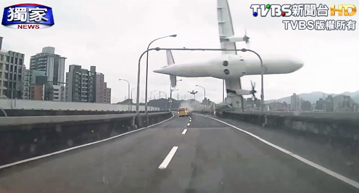 This image taken from video provided by TVBS shows a commercial airplane clipping an elevated roadway just before it careened into a river in Taipei, Taiwan.