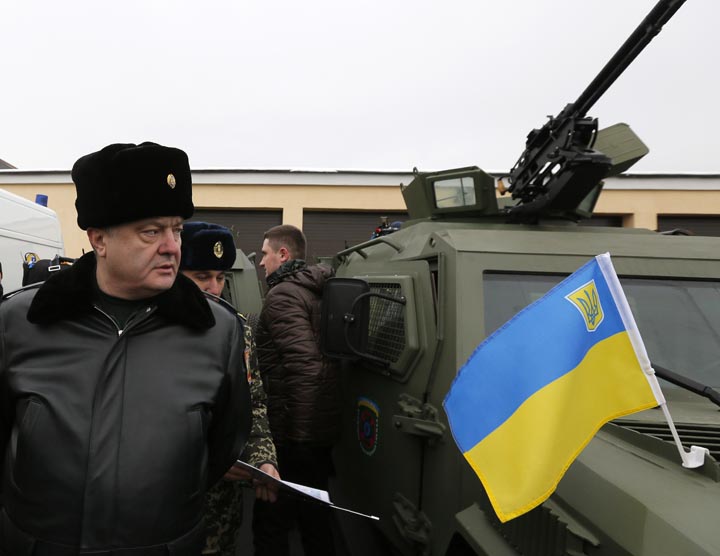 Ukrainian President Petro Poroshenko, left, inspects military armoured personnel carriers during his visit to the State Border Guard Service in Kiev, Ukraine, Saturday, Feb. 14, 2015.