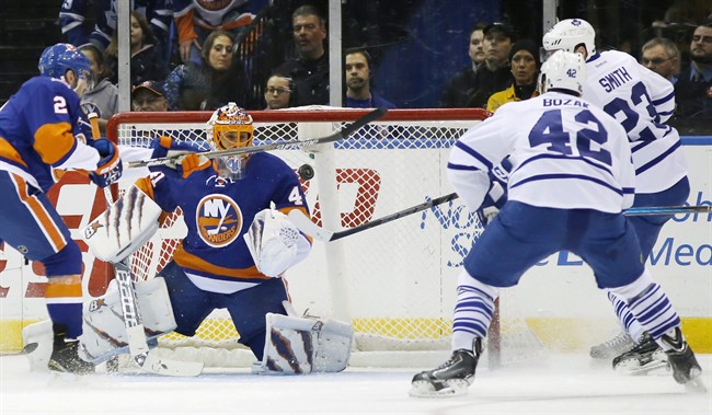 New York Islanders goalie Jaroslav Halak (41) of Slovakia watches the puck as a shot scored by Toronto Maple Leafs Trevor Smith (23) flies in front of him with New York Islanders defenseman Nick Leddy (2) defending in the second period of an NHL hockey game at Nassau Coliseum in Uniondale, N.Y., Thursday, Feb. 12, 2015. 