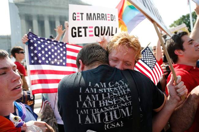Michael Knaapen, left, and his husband John Becker, right, embrace outside the Supreme Court in Washington on June 26, 2013.