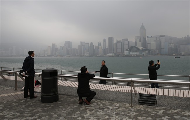 Tourist take photographs at the waterfront of Victoria Harbor in Hong Kong Wednesday, Feb. 18, 2015.