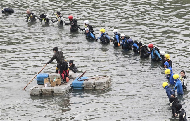 Divers continue to search for missing persons at the site of a commercial plane crash in Taipei, Taiwan, Friday, Feb. 6, 2015.