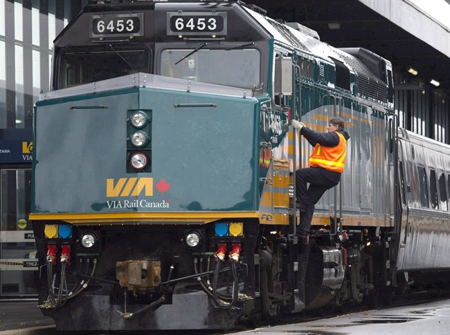 A Via Rail employee climbs aboard a locomotive.