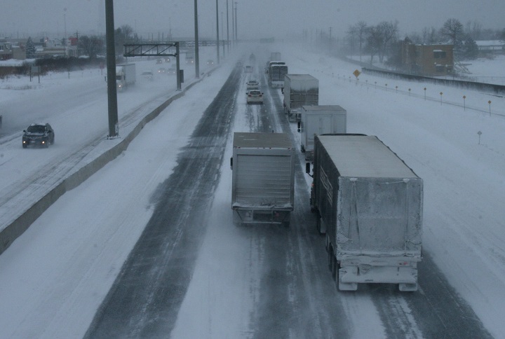 Truck traffic on the eastbound Queen Elizabeth Way moves on mostly dry pavement in Oakville, Ont., Monday, Feb. 2, 2015.
