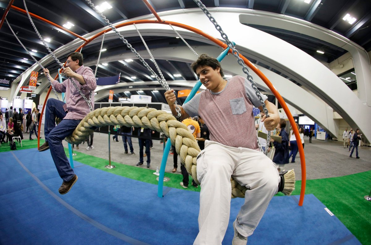 Phillip Chu Joy, left, and Juan Pablo Cabrejos Meza, right, ride a swing in the Biba smart playground at the Game Developers Conference, Wednesday, March 4, 2015, in San Francisco. 