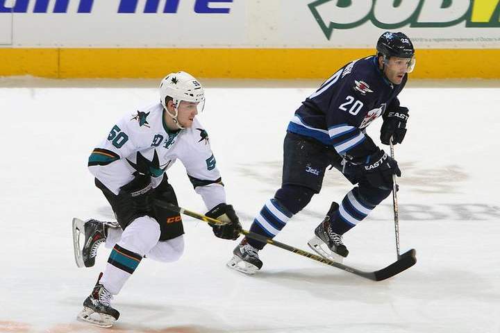 Chris Tierney of the San Jose Sharks and Lee Stempniak of the Winnipeg Jets chase the play down the ice during third period action on Tuesday at the MTS Centre in Winnipeg.