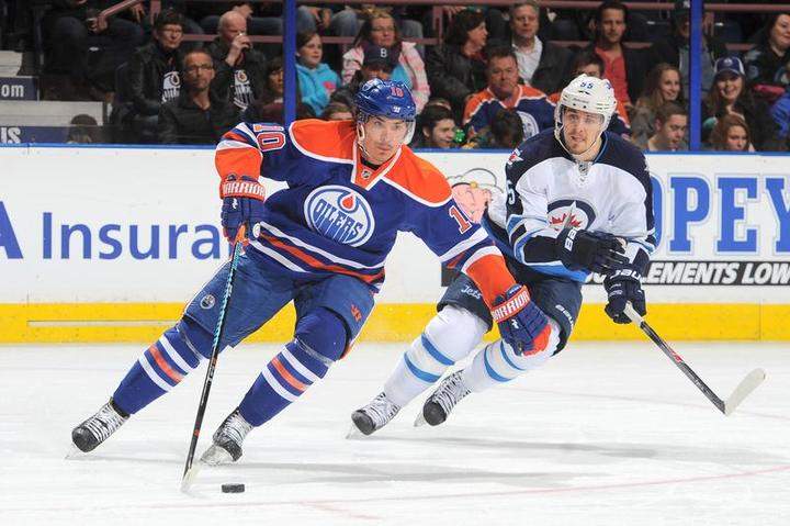 Nail Yakupov #10 of the Oilers battles for the puck against Mark Scheifele #55 of the Winnipeg Jets on March 23, 2015 in Edmonton.