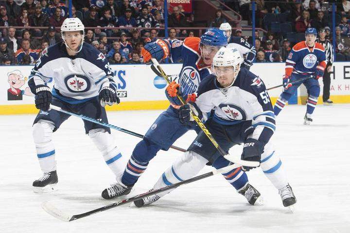 Ryan Nugent-Hopkins #93 of the Edmonton Oilers battles for the puck against Mark Scheifele #55 of the Winnipeg Jets during the game on Monday at Rexall Place in Edmonton.