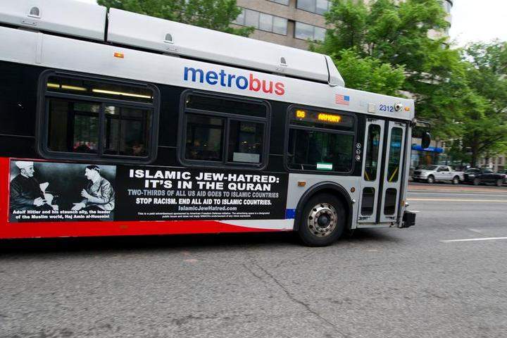 A Metro bus, featuring a controversial ad, drives on a street in Washington, DC on May 21, 2014. The Philadelphia transit authority is being forced to adopt these ads.