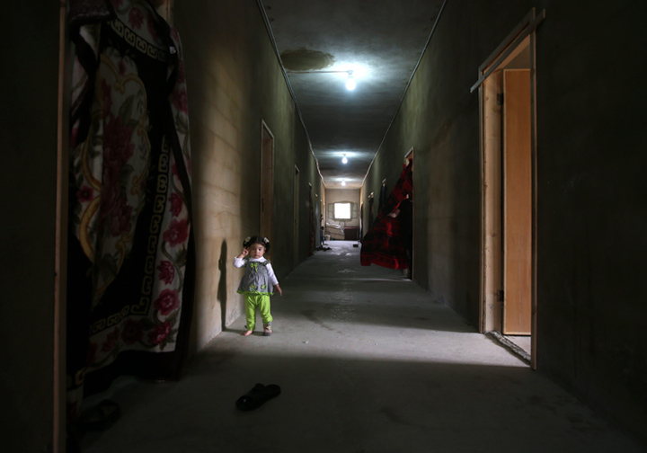 A Syrian girl stands in the corridor of a refugee centre where she lives with her family in northern Lebanon in this image from May, 2014.