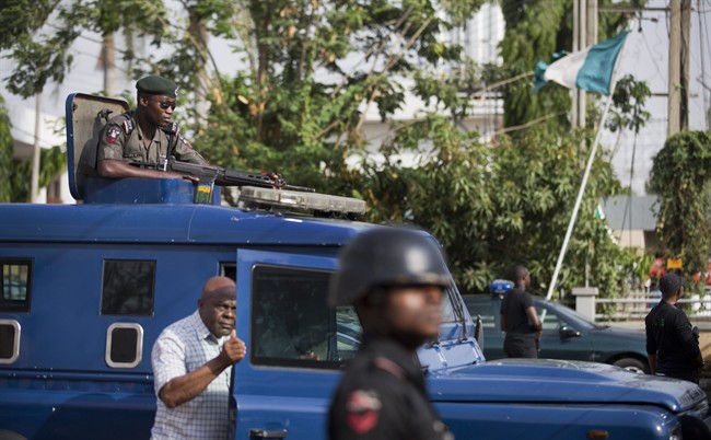 Nigerian police officers and State Security Service agents keep guard as a convoy carrying ballot papers and other electoral material is delivered to the election commission office in the Area 10 neighborhood of the capital Abuja, Nigeria Wednesday, March 25, 2015. Hundreds of civilians, including many children, have been abducted and used as human shields by Boko Haram extremists, a top Nigerian official confirmed Wednesday, with Nigeria's battle against the Islamic extremists due to be a major issue for the elections to be held Saturday.