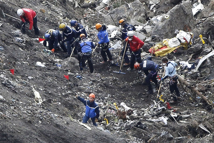 Rescue crews work are seen amongst the  debris from the Germanwings jet that crashed near Seyne-les-Alpes, France, Thursday, March 26, 2015. 