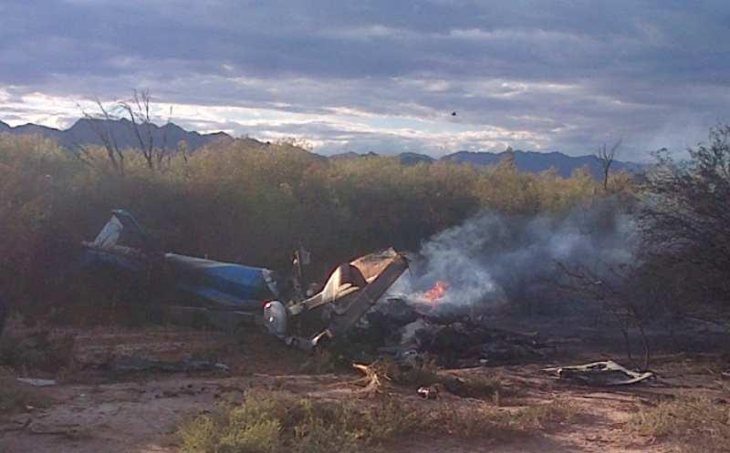 A man stands near one of two helicopters that crashed near Villa Castelli in the La Rioja province of Argentina, Monday, March 9, 2015. Two helicopters with passengers who were filming a documentary crashed Monday in the remote area of northwest Argentina, killing all 10 people on board both aircrafts, authorities said. 