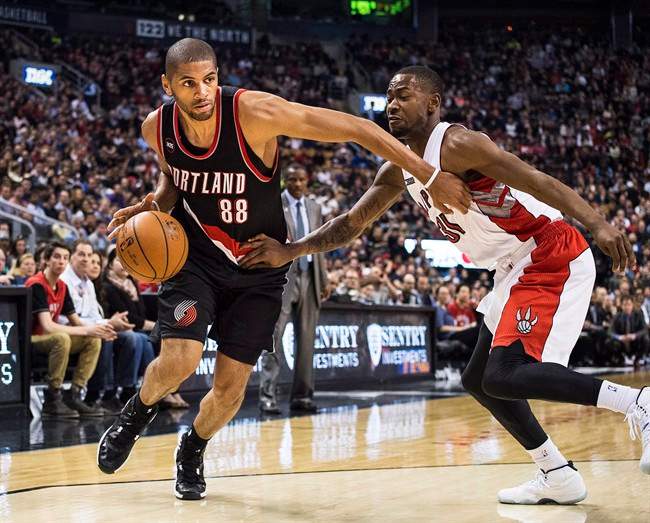 Portland Trail Blazers' Nicolas Batum, left, moves to the net against Toronto Raptors' Terrence Ross during second half NBA action in Toronto on Sunday, March 15 2015.