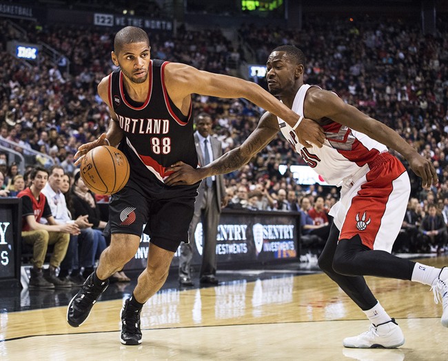 Portland Trail Blazers' Nicolas Batum, left, moves to the net against Toronto Raptors' Terrence Ross during second half NBA action in Toronto on Sunday, March 15 2015.