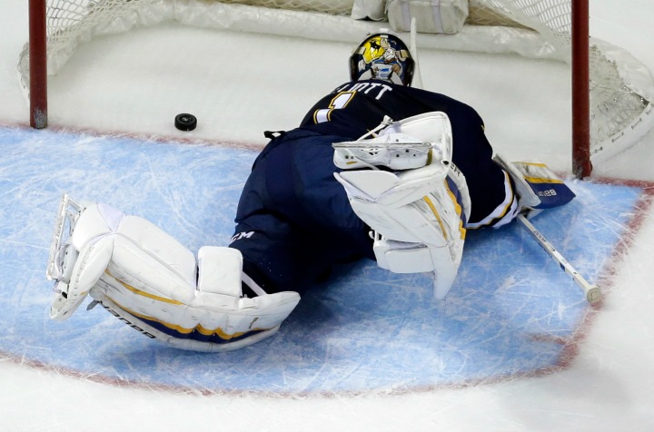 St. Louis Blues goalie Brian Elliott watches as a puck shot by Vancouver Canucks' Nick Bonino slips into the net for a goal during the second period of an NHL hockey game Monday, March 30, 2015, in St. Louis. The Canucks won 4-1. 