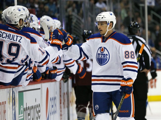 Edmonton Oilers defenseman Brandon Davidson, right, is congratulated by teammates after scoring a goal against the Colorado Avalanche in the first period of an NHL hockey game Monday, March 30, 2015, in Denver. 